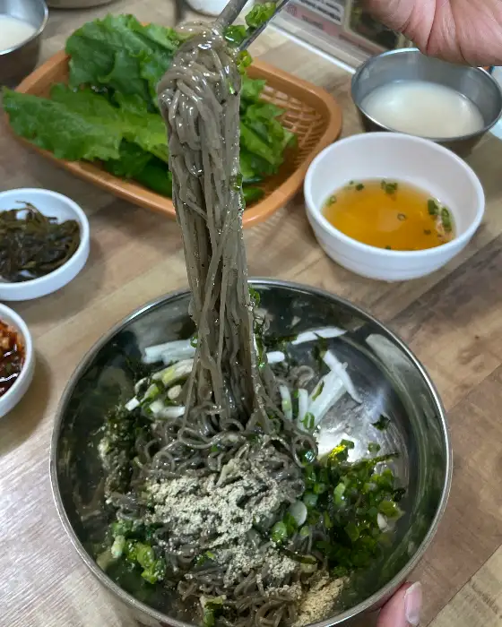 들기름 막국수를 맛있게 비비는 모습