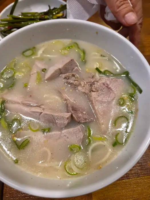 고기국수 클로즈업, 큼직한 고기 조각과 쫄깃한 면발이 돋보임