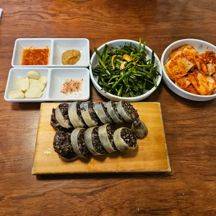 고기국수와 함께 나온 김치, 부추무침, 마늘, 젓갈 등 반찬 구성