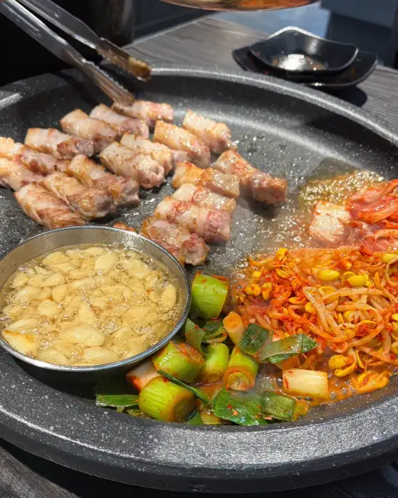 구워지고 있는 삼겹살과 곁들임 반찬