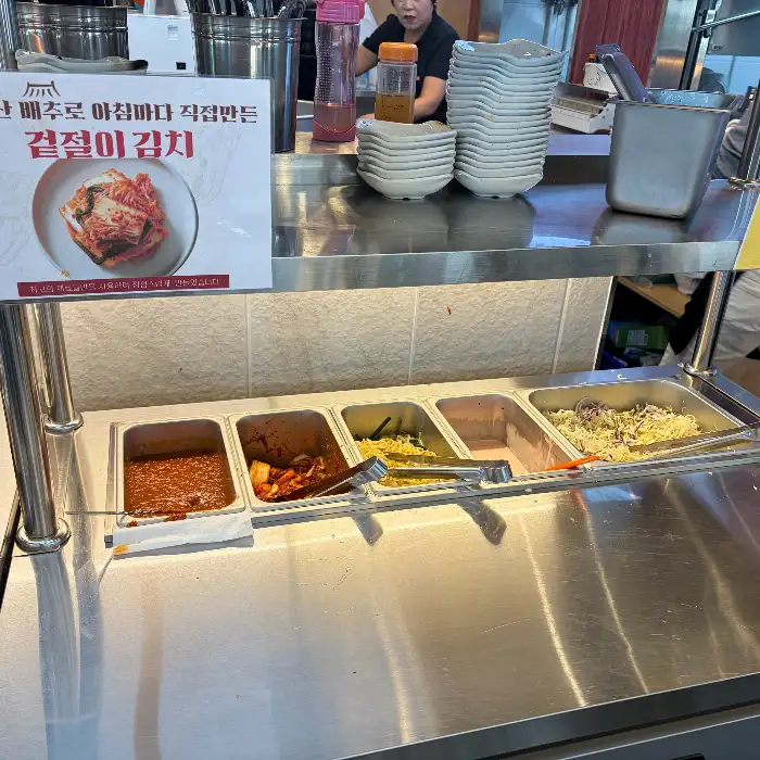 직원들이 쌈과 반찬을 채우는 셀프바 모습