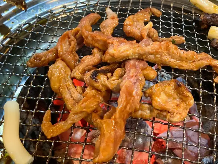 숯불 위에서 익어가는 닭갈비 조각들