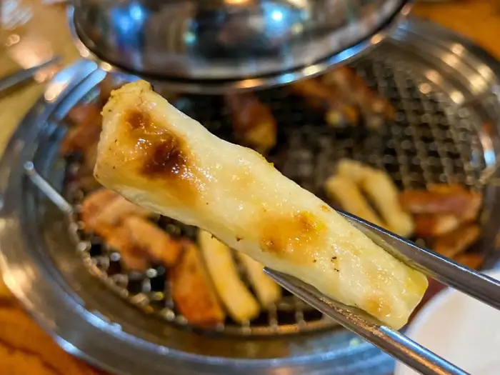 집게로 집은 숯불에 구워진 떡