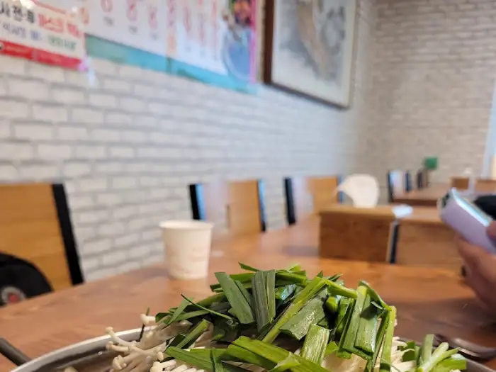 전골 냄비 위 산더미처럼 쌓인 파와 버섯
