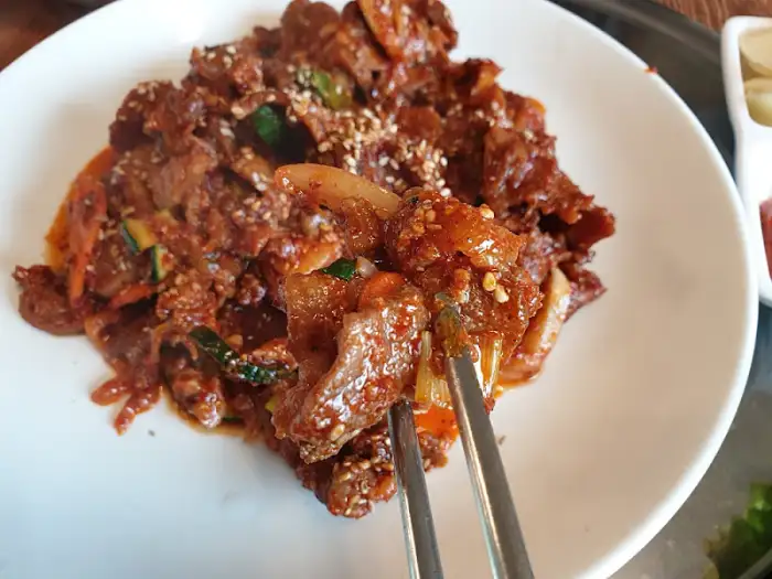 집게로 집어 올린 산더미 불고기 한 점