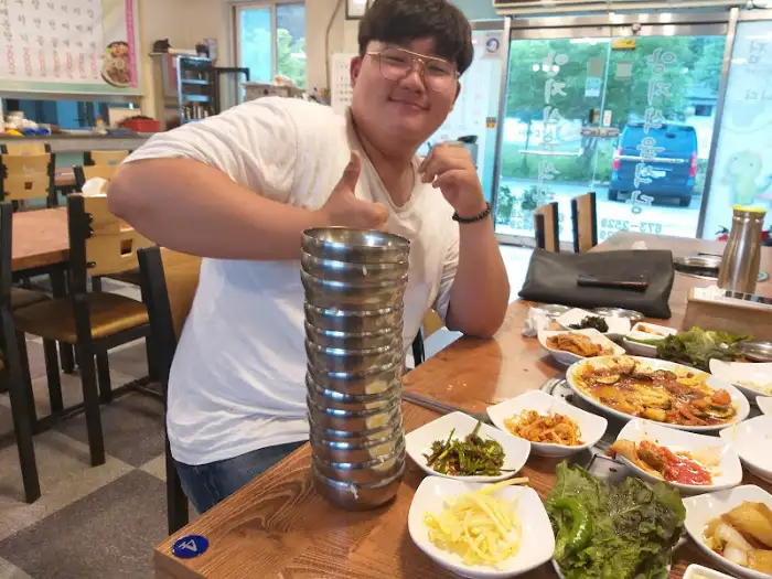 엄지척을 하며 불고기 냄비를 가리키는 사람