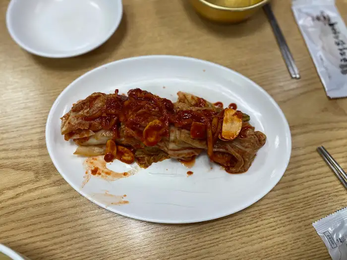 하얀 접시에 푸짐하게 담긴 김치, 밤과 굴이 들어있을 법한 모습