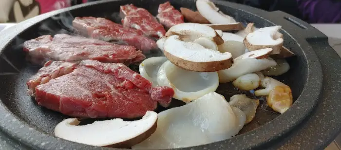 불판 위에 푸짐하게 올라간 삼합 재료들