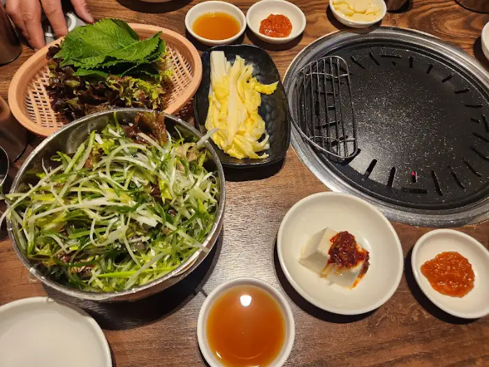 숯불 위에서 익어가는 소갈비와 밑반찬
