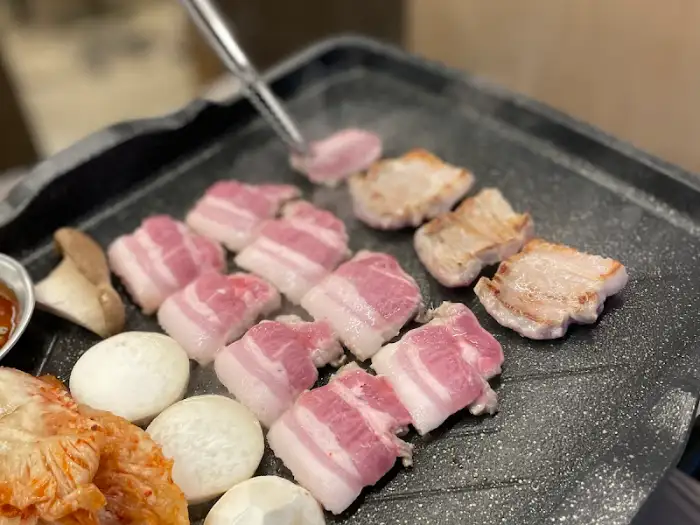 불판 위에서 익어가는 삼겹살 조각들