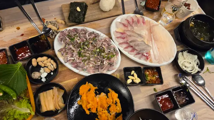 다양한 회와 곁들임 찬이 차려진 식탁