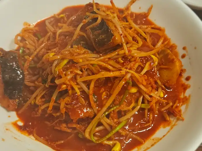 아구찜 클로즈업 사진. 아구살과 콩나물, 채소의 질감이 생생하게 보입니다.