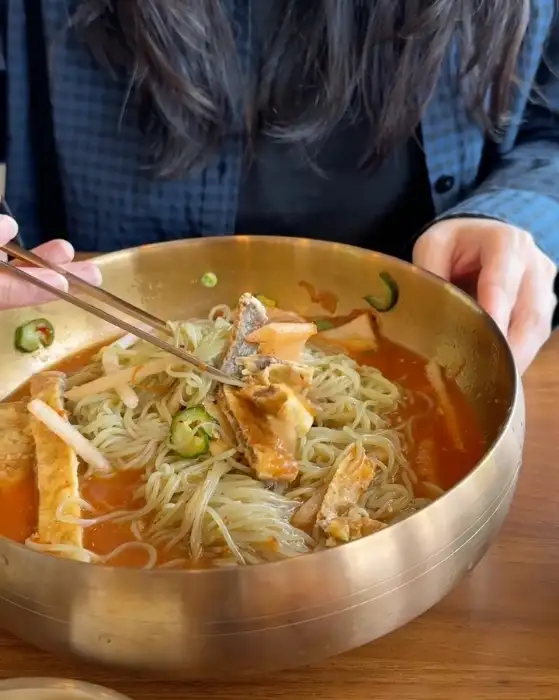 직원분이 육전을 집어 냉면에 싸 먹는 모습