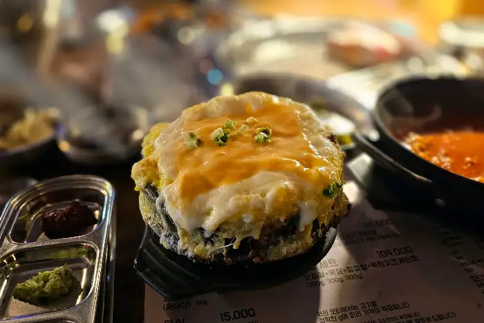 김이 모락모락 나는 치즈 폭탄 계란찜의 근접 촬영 사진