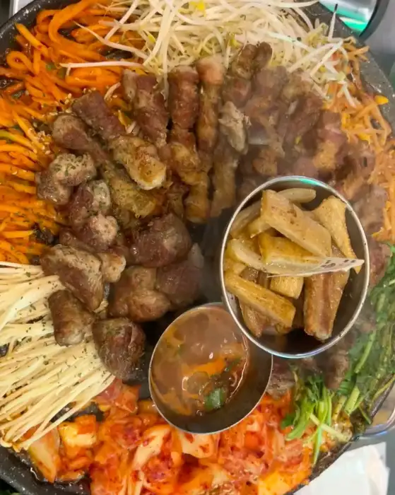 다채로운 채소와 함께 푸짐하게 담긴 돼지고기 모둠 한 판