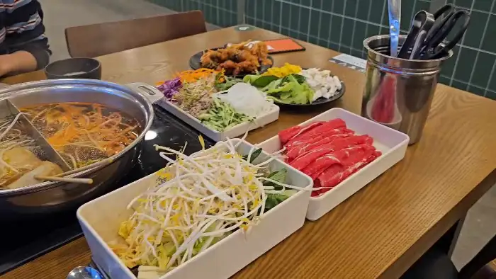 테이블에 차려진 샤브샤브와 샐러드바 메뉴들