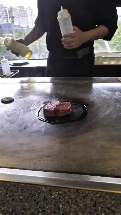 셰프가 철판 위에서 스테이크를 조리하는 모습