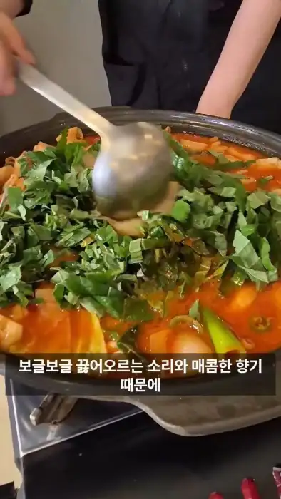 끓고 있는 곱창전골에 채소를 넣는 모습