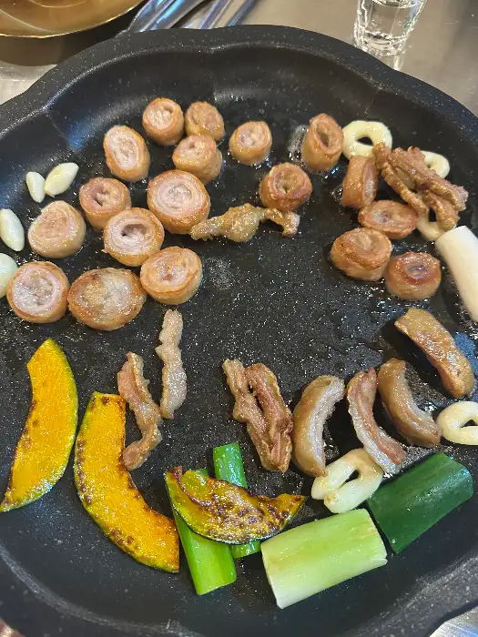 막창과 각종 채소가 불판 위에서 구워지고 있는 모습