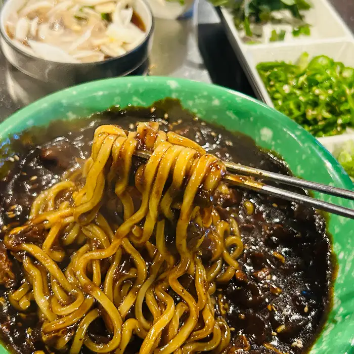 짜장면 면발을 젓가락으로 집어 올리는 모습