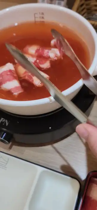 샤브샤브 육수에 고기를 넣고 있는 모습