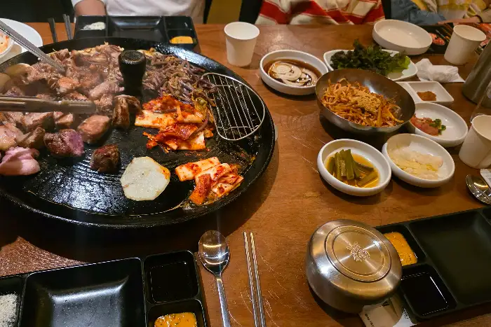 솥뚜껑 위에 올라간 다양한 반찬과 고기