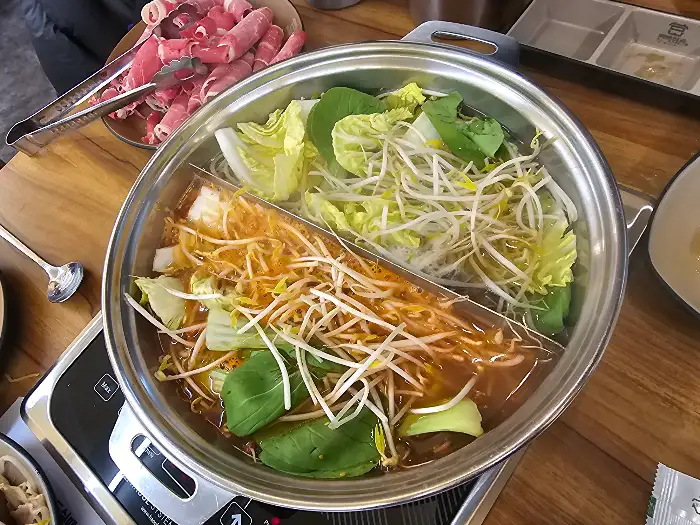 편백찜과 샤브샤브가 끓고 있는 냄비의 모습