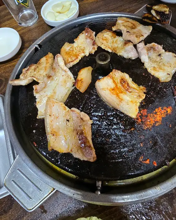 솥뚜껑 삼겹살 굽는 사진