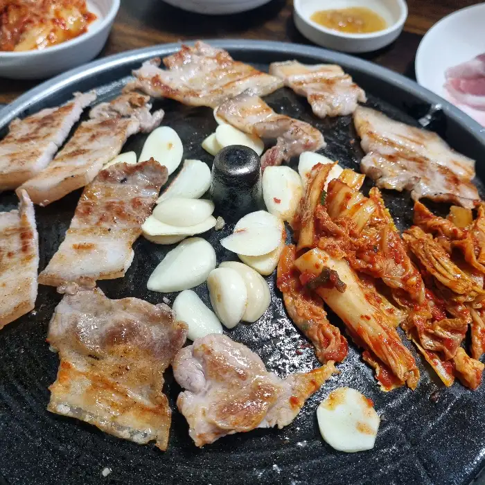 삼겹살, 김치, 마늘 굽는 사진
