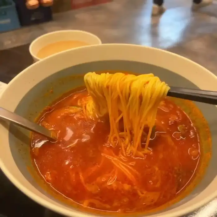 김이 모락모락 나는 마라탕 국물에 젓가락으로 건져 올린 옥수수면