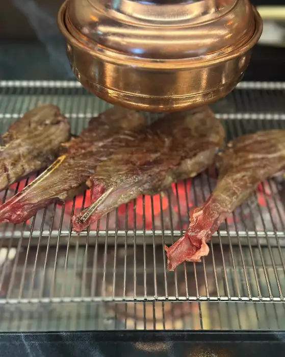 두툼한 양갈비 살이 숯불 위에서 구워지고 있는 모습