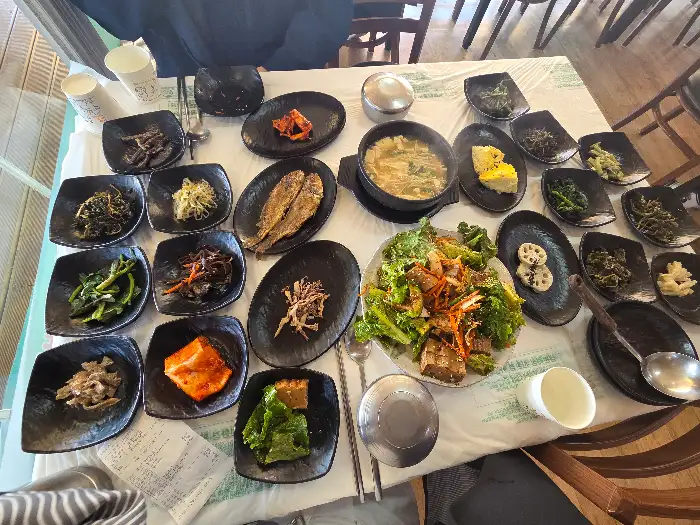 다양한 나물 반찬과 메인 요리가 차려진 테이블