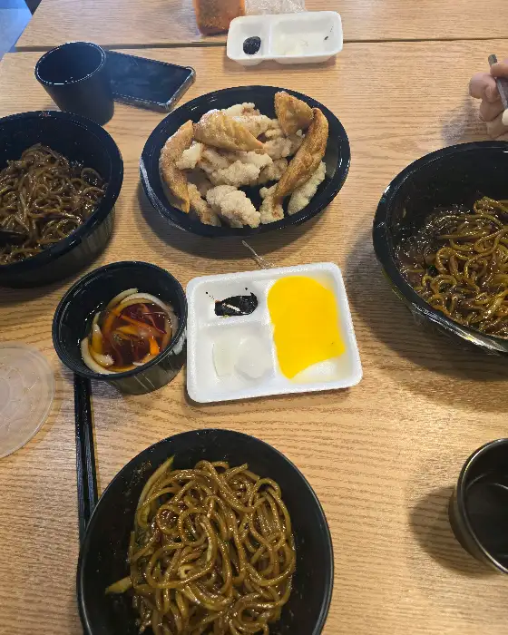 탕수육과 짜장면이 함께 놓인 테이블 사진