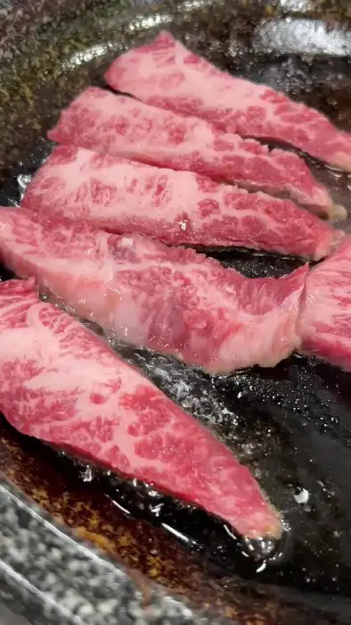 잘 익은 소고기 조각을 집게로 집은 사진