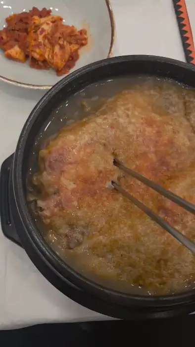 젓가락으로 누룽지 삼계탕을 집는 모습