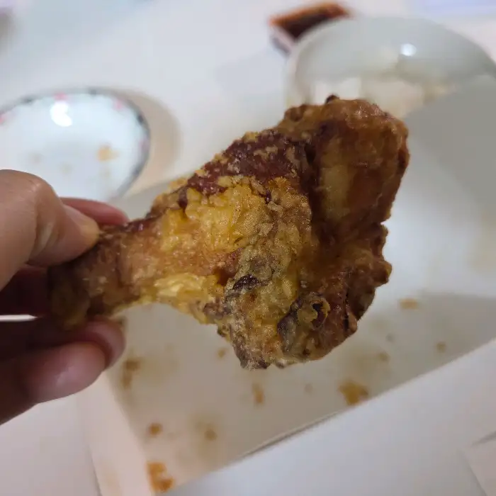손에 들고 있는 후라이드 치킨 조각