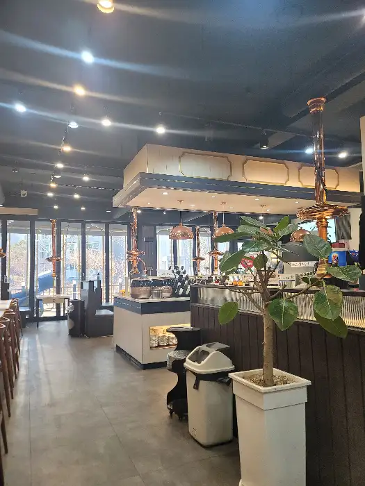 식당 내부 홀 전경. 많은 테이블이 있고, 곳곳에 조명이 설치되어 있다.