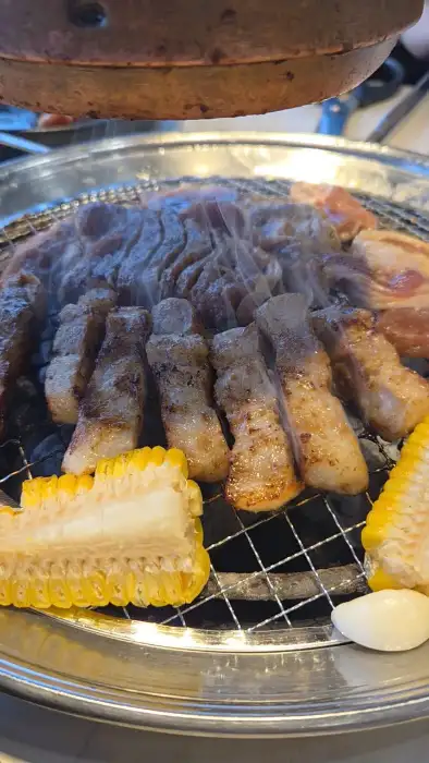 숯불 위에 지글지글 구워지는 갈비와 옥수수, 마늘.