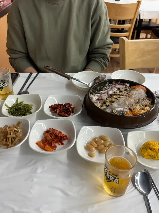 푸짐하게 차려진 상차림과 함께 맥주잔이 놓여 있습니다.