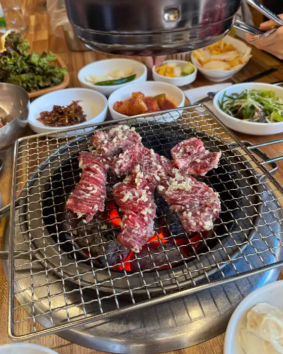 다양한 부위의 갈비가 불판 위에서 익고 있는 모습