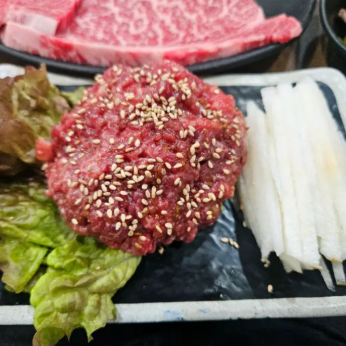 잘 익은 소고기 한 점을 집는 집게