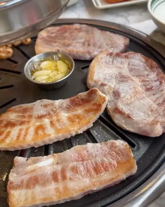 불판 위에서 맛있게 익어가는 목살과 삼겹살