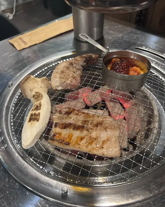 초벌된 고기가 숯불 위에서 익어가는 모습