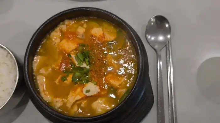 순두부 찌개와 밥, 젓가락, 숟가락이 함께 놓인 모습