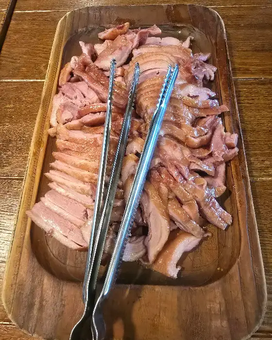 다양한 부위의 훈제 오리가 푸짐하게 담긴 나무 쟁반