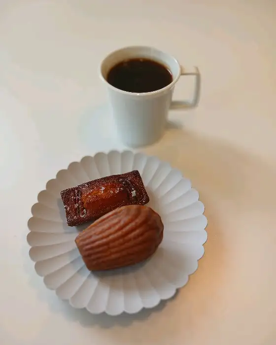 컵과 접시에 담긴 마들렌과 디저트 모습