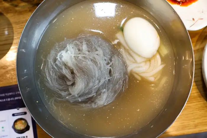 시원한 냉면 한 그릇에 담긴 면과 계란, 국물