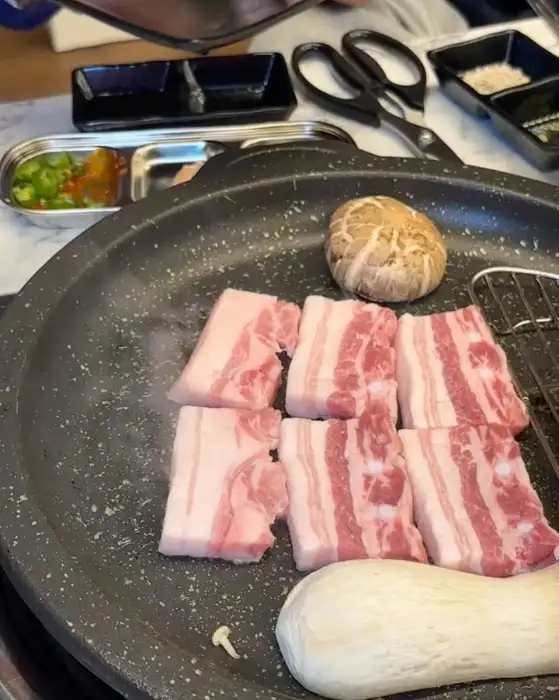 노릇하게 구워지고 있는 삼겹살과 통버섯