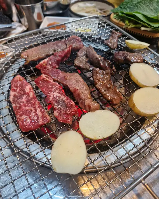 숯불 위에서 맛있게 익어가고 있는 갈비살과 감자