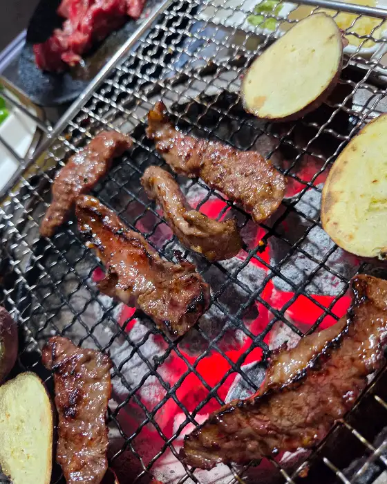 숯불 위에서 지글지글 익어가는 갈비살 조각들
